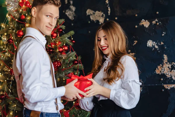 genç çekici kız bir yılbaşı ağacı, yılbaşı tema arka plan üzerinde adamdan mevcut almak