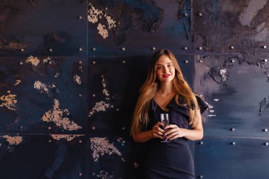 bir bardak şampanya veya şarap duvar koyu arka plan üzerine genç çekici kızla