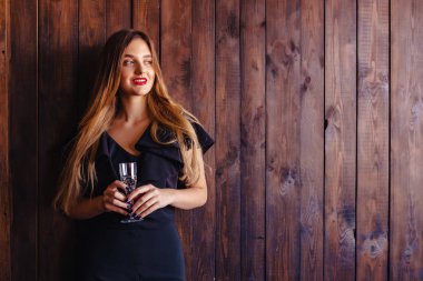 bir bardak şampanya veya şarap duvar koyu arka plan üzerine genç çekici kızla