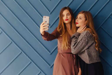 iki çekici şık genç kızla akıllı telefonlar üzerinde basit arka plan