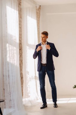 anıtsal yüzü aydınlık iç, moda, iş aksanı olan bir kostüm ceketli şık genç çocuk