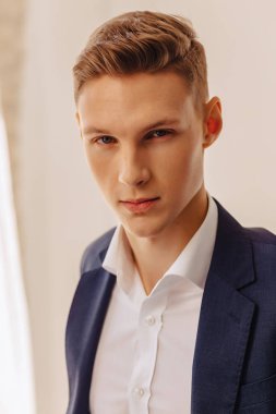 closup portre şık genç ceketli çocuk bir kostüm anıtsal bir yüzü aydınlık iç, moda, iş aksan ile