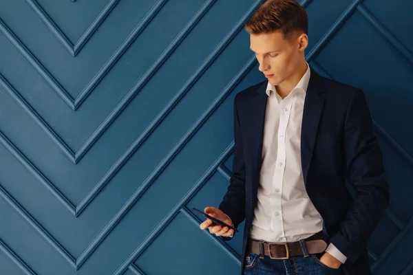 stylish young guy with a phone, young businessman, freelancer work, simple aqua background