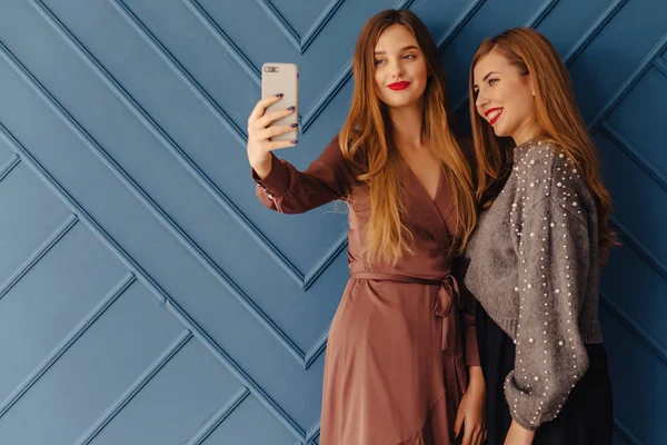 Zwei Attraktive Junge Mädchen Mit Smartphones Auf Einfachem Aqua Hintergrund — Stockfoto