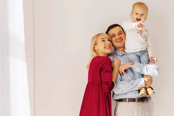 beautiful family with a small daughter, a simple background, happiness and joy in apartments