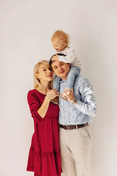 beautiful family with a small daughter, a simple background, happiness and joy in apartments