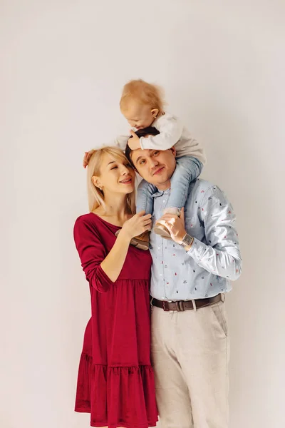 beautiful family with a small daughter, a simple background, happiness and joy in apartments