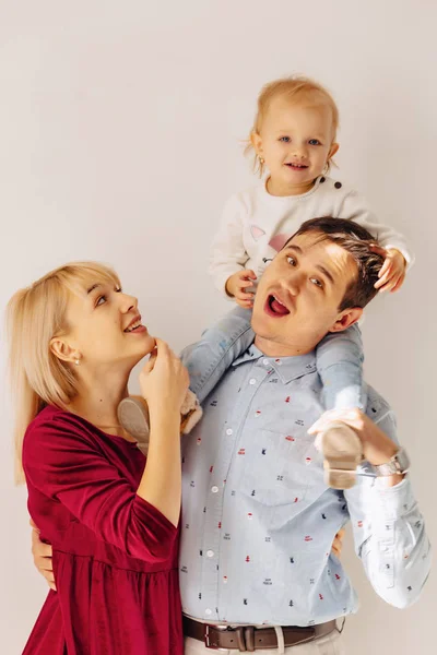 beautiful family with a small daughter, a simple background, happiness and joy in apartments