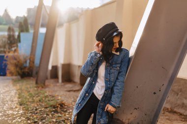 Sonbahar güneşli şehirde bir kot ceket genç güzel kız yürüyor