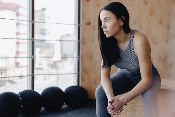 Mladá dívka v sportovní oblečení do tělocvičny v jednoduché pozadí, motiv fitness, crossfit a sportu — Stock fotografie