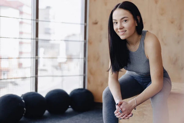 Mladá dívka v sportovní oblečení do tělocvičny v jednoduché pozadí, motiv fitness, crossfit a sportu — Stock fotografie