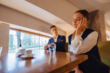 şık bir çift sabah kahvesi kafede içecekler, kız uyuyor, Çocuk pencereden dışarı bakarak