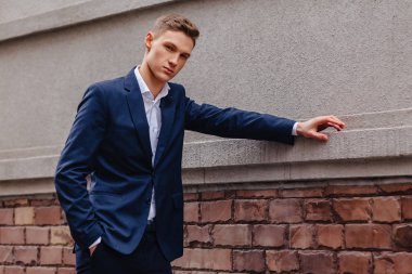 ahşap ve taş duvarları yakınında sakin bir şehirde anıtsal bir yüz ile genç şık adam yürüyor