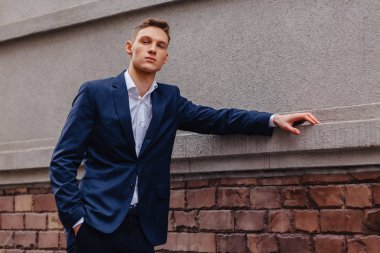 ahşap ve taş duvarları yakınında sakin bir şehirde anıtsal bir yüz ile genç şık adam yürüyor