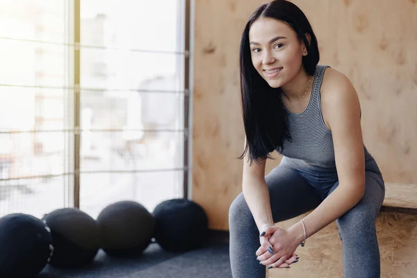 Mladá dívka v sportovní oblečení do tělocvičny v jednoduché pozadí, téma fitness a sportu — Stock fotografie