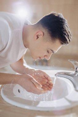 sabah hijyen, çocuk bir lavabo sprey su ile yıkanır