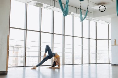 panoramik pencerelerin arka planına karşı katta Yoga ile Fitness egzersizleri yapan genç çekici kız