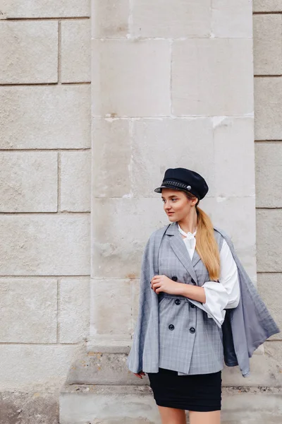 Uma garota bonita e fofa em um terno elegante anda pela cidade e posa — Fotografia de Stock