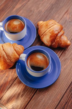 ahşap arka planda iki bardak kahve ve kruvasanlar, iyi ışık, sabah atmosferi