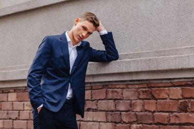 ahşap ve taş duvarları yakınında sakin bir şehirde anıtsal bir yüz ile genç şık adam yürüyor