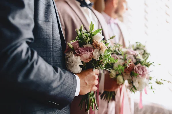 The groom holds a wedding bouquet in his hands — Stock Photo, Image