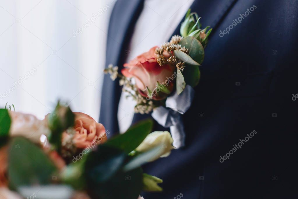 the groom holds a wedding bouquet in his hands