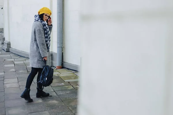 Menina atraente em óculos de casaco e amarelo Beret freestyle andando — Fotografia de Stock