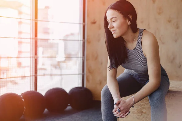 Mladá dívka v sportovní oblečení do tělocvičny v jednoduché pozadí, motiv fitness, crossfit a sportu — Stock fotografie