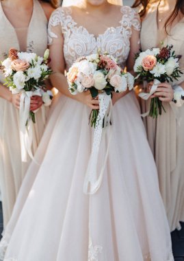 Gelin elinde bir düğün buketi tutuyor.