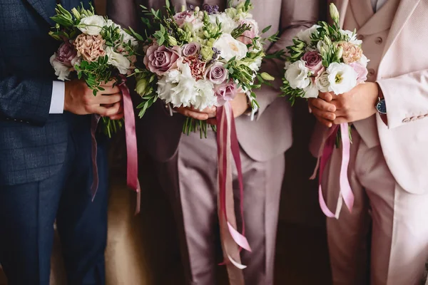 The groom holds a wedding bouquet in his hands — Stock Photo, Image