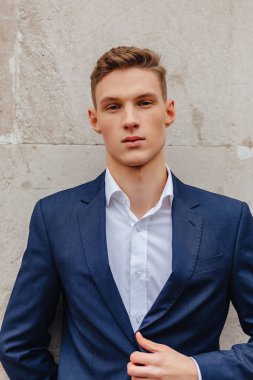 ahşap ve taş duvarları yakınında sakin bir şehirde anıtsal bir yüz ile genç şık adam yürüyor