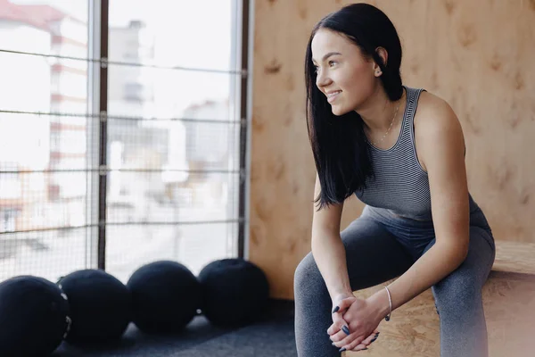 Mladá dívka v sportovní oblečení do tělocvičny v jednoduché pozadí, motiv fitness, crossfit a sportu — Stock fotografie