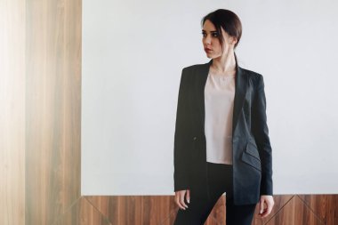 Bir ofis veya izleyici düz beyaz bir arka plan üzerinde iş tarzı giysiler Genç çekici duygusal kız