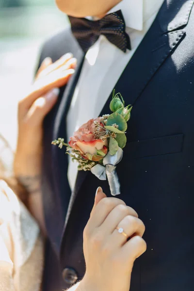 Le marié tient un bouquet de mariage dans ses mains — Photo