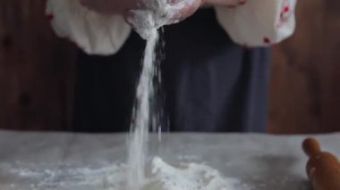 yaşlı kadın elleri masaya un döker, ekmek veya köfte, Ukrayna geleneği bir hamur yoğurma