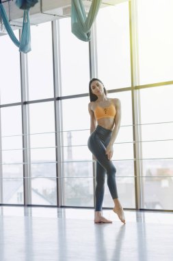 panoramik pencerelerin arka planına karşı katta Yoga ile Fitness egzersizleri yapan genç çekici kız