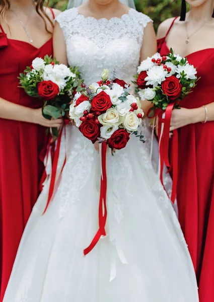 A noiva segura um buquê de casamento em suas mãos — Fotografia de Stock