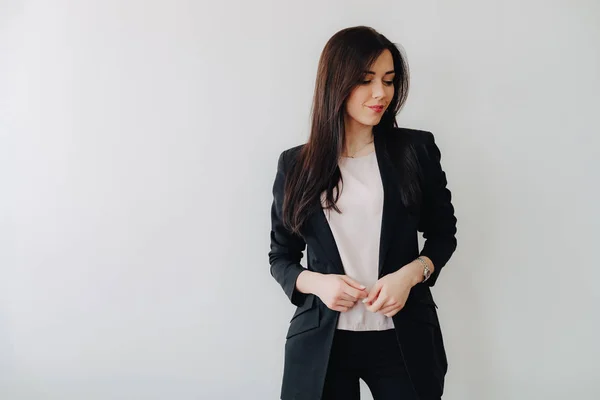 Bir ofis veya izleyici düz beyaz bir arka plan üzerinde iş tarzı giysiler Genç çekici duygusal kız