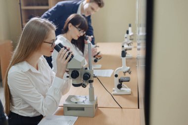 iki kız ve bir erkek mikroskoplar ile çalışmak