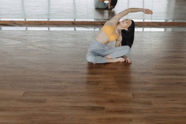 genç çekici kız ahşap bir katta yoga yapıyor, germe ve rahatlatıcı