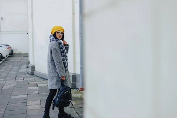 Приваблива молода дівчина в окулярах в пальто і жовтий Берет вільний стиль ходьби — стокове фото