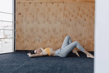 Ahşap bir arka planda yerde Yoga ile Fitness egzersizleri yapan genç çekici kız
