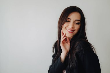 Bir ofis veya izleyici düz beyaz bir arka plan üzerinde iş tarzı giysiler Genç çekici duygusal kız