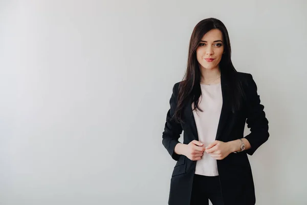 Bir ofis veya izleyici düz beyaz bir arka plan üzerinde iş tarzı giysiler Genç çekici duygusal kız