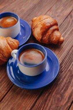 ahşap arka planda iki bardak kahve ve kruvasanlar, iyi ışık, sabah atmosferi