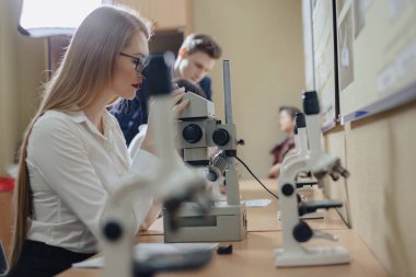 iki kız ve bir erkek mikroskoplar ile çalışmak