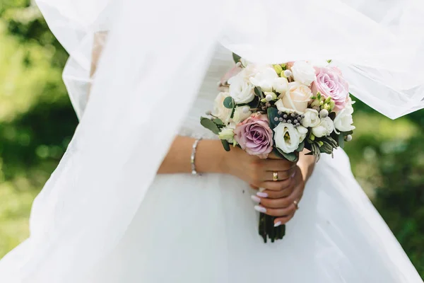 The bride holds a wedding bouquet in her hands — Stock Photo, Image