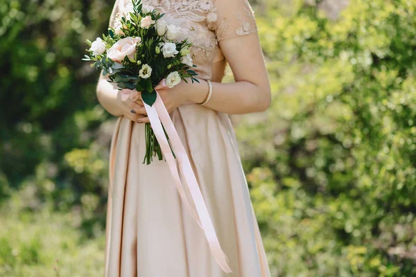 La mariée tient un bouquet de mariage dans ses mains — Photo