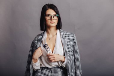 Makyaj fırçalarıyla arka planda poz veren çekici genç bir iş kızı. Makyaj ve yüz estetiği kavramı.