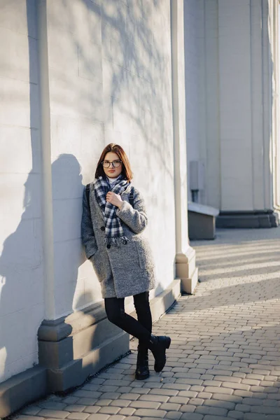 Attraktive Junge Mädchen Mit Brille Mantel Auf Städtischem Hintergrund Die lizenzfreie Stockfotos